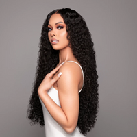 Woman with long, curly black hair against a gray background