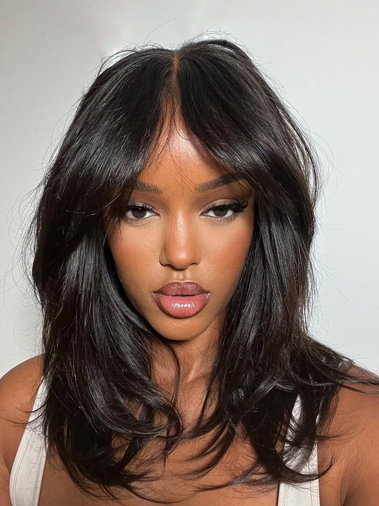Woman with long, dark hair against a plain background