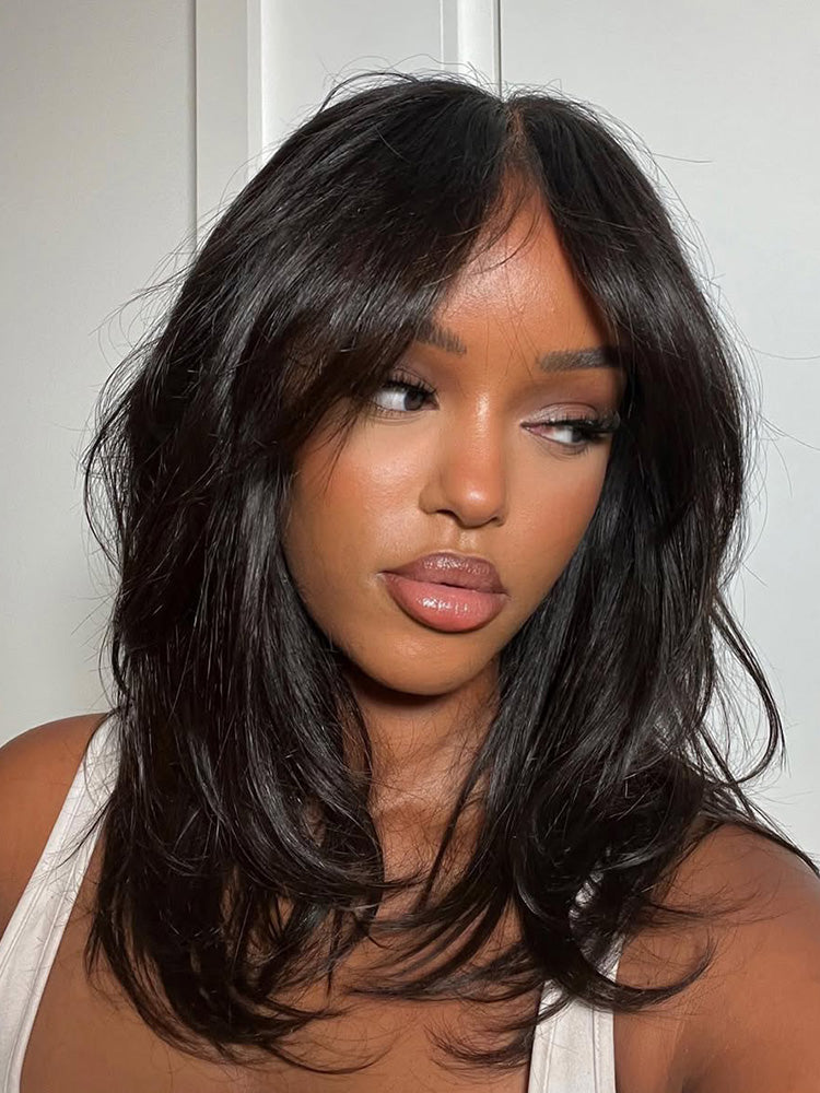 Woman with long, dark hair wearing a white top against a white background
