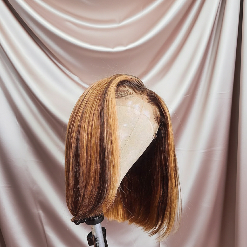 Brown bob wig on a mannequin head against a beige draped fabric background