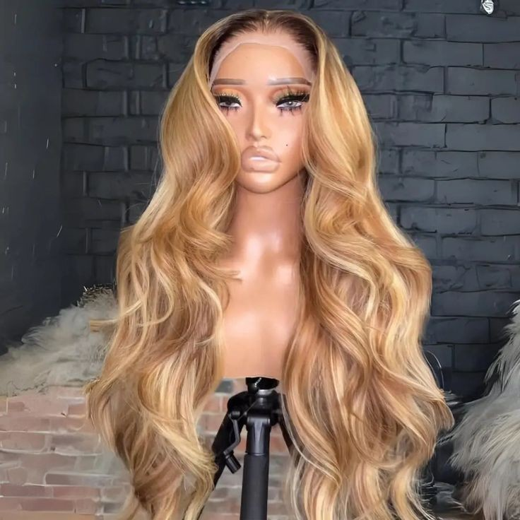 Long wavy blonde lace front wig displayed on mannequin with makeup against dark wall