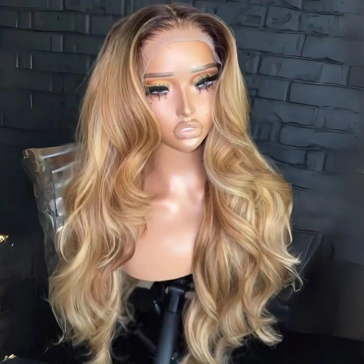 Mannequin head with long wavy blonde lace front wig against black brick wall