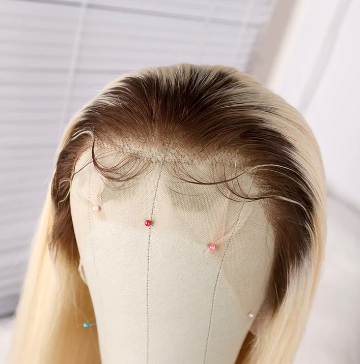 Blonde hair wig on a mannequin head with a plain background