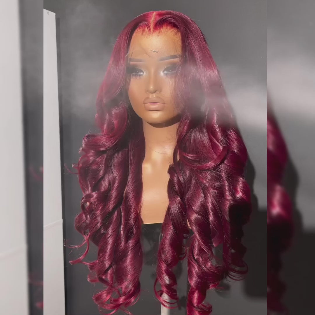 Burgundy transparent body wave human hair wig displayed on a mannequin with voluminous curls and a natural hairline.